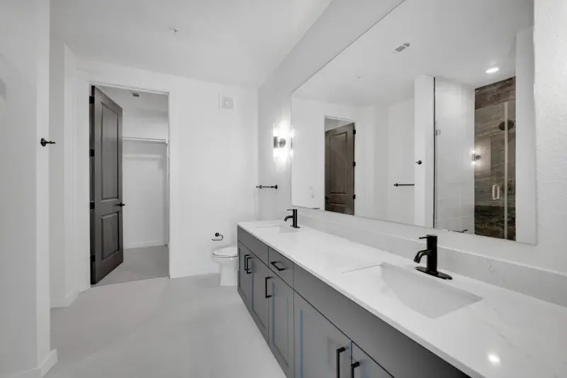 Bright modern bath with double vanity and glass walk-in shower; clean and crisp. — Dallas/Fort Worth real estate photography