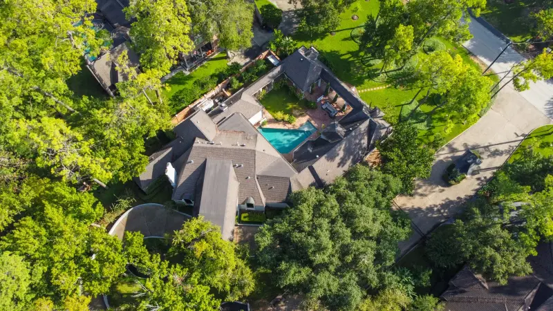 Pool with lit fire bowl, deep-blue water, sleek modern home behind. — Houston real estate photography