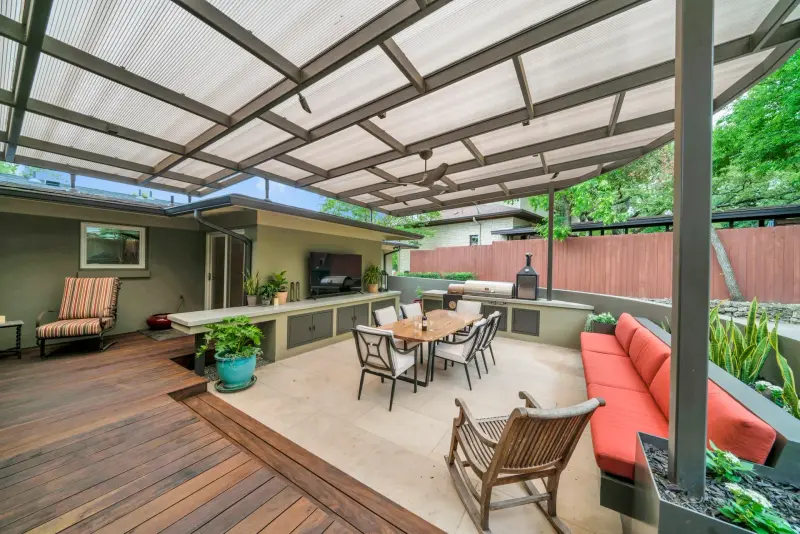 Glass-roofed covered patio with an outdoor kitchen and lounge — Austin–San Antonio corridor real estate photography