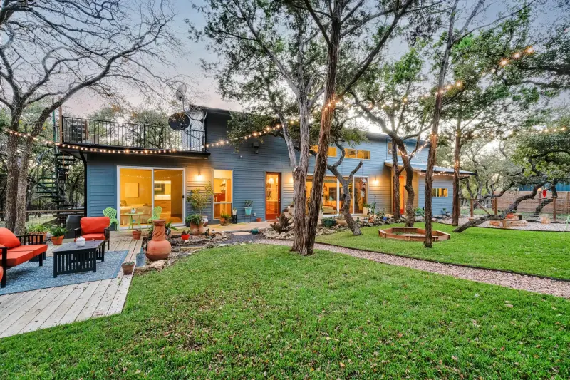 Hill Country home at dusk with string lights and a warm interior glow — Austin–San Antonio corridor real estate photography