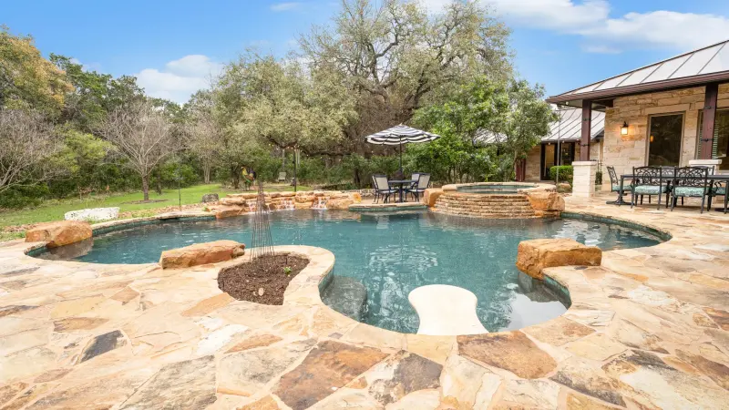 Hill Country estate pool with spa and rock waterfall — Austin–San Antonio corridor real estate photography