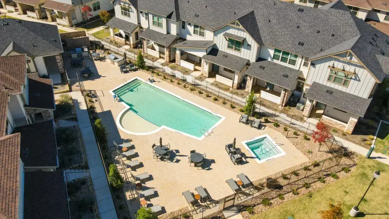 Crisp aerial of community pool amenity, clean blue water and tidy decking in strong directional light. — Dallas/Fort Worth real estate photography
