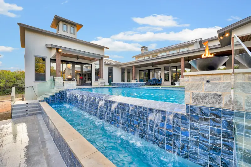 Contemporary home with a glass-tile spillway pool and outdoor fireplace. — San Antonio real estate photography