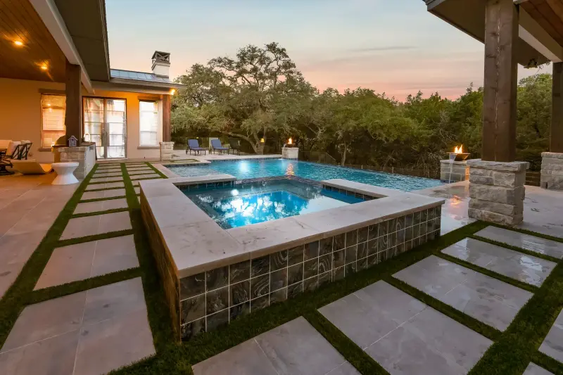 Modern pool at blue hour with the lit interior reflecting on the water. — San Antonio real estate photography