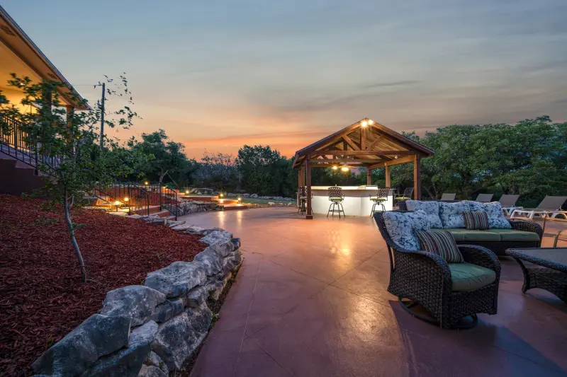 Crisp blue-sky pool and spa with navy umbrellas and loungers. — Austin–San Antonio corridor real estate photography