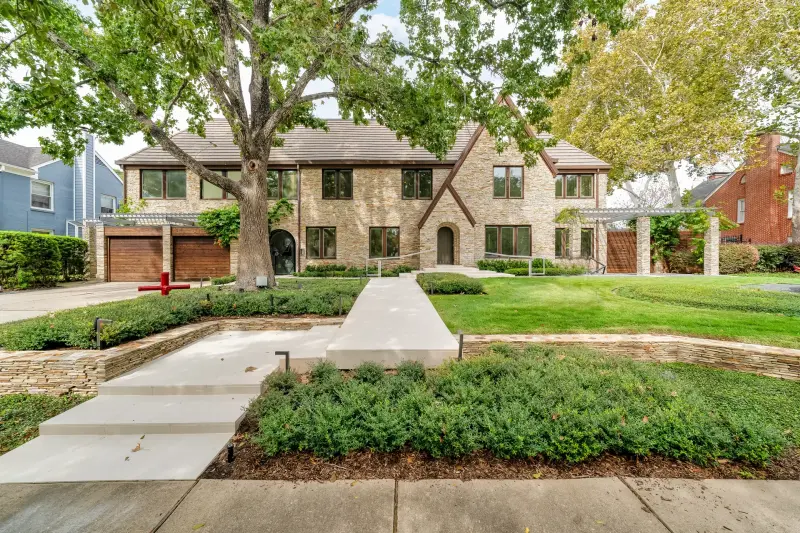 Grand stone estate with a sweeping walkway and mature hedges. — Houston real estate photography